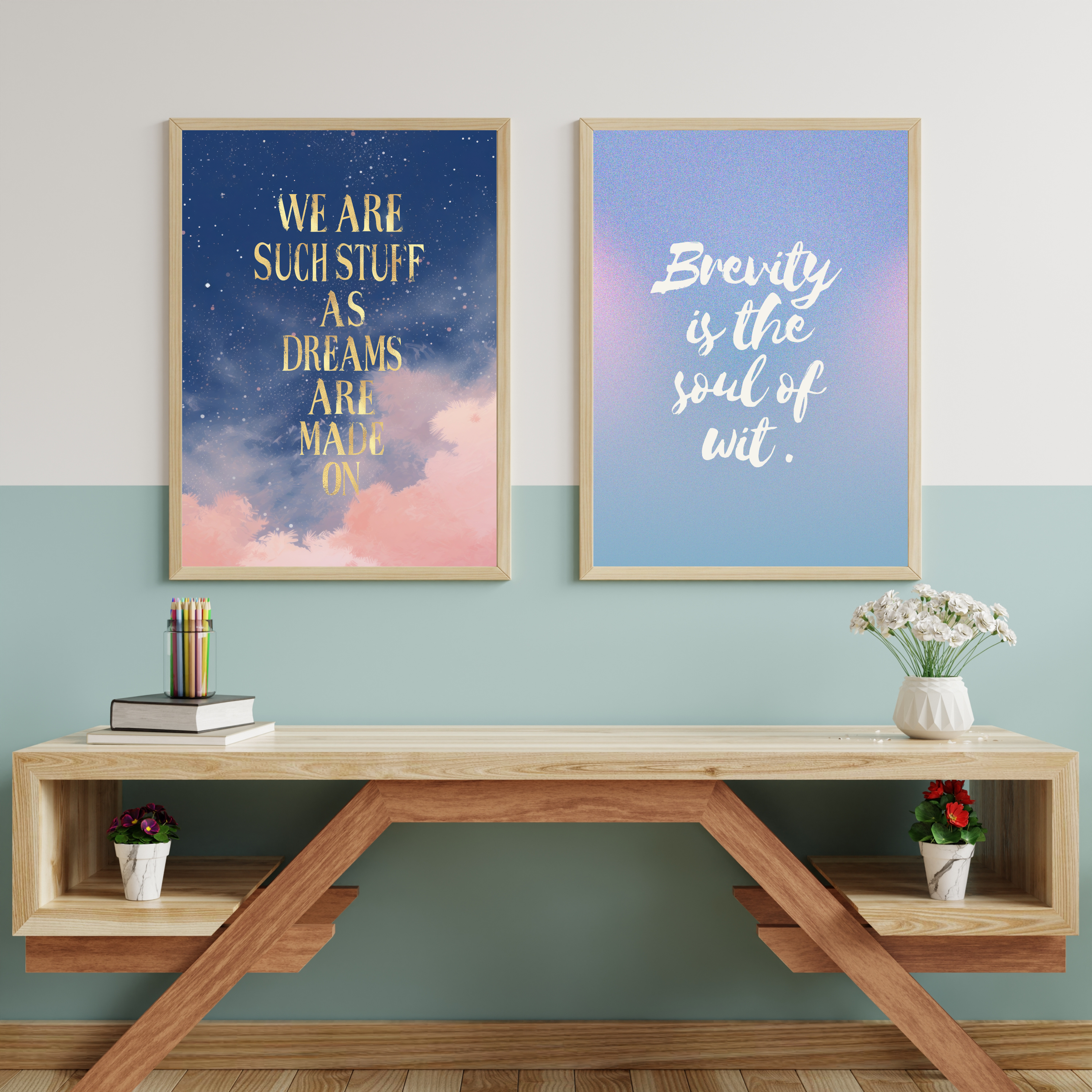 Two framed wall art prints above a modern wooden desk with flowers and books: one print shows a dreamy night sky with pink clouds and gold text ‘We are such stuff as dreams are made on’, the other a blue gradient with white text ‘Brevity is the soul of wit.’